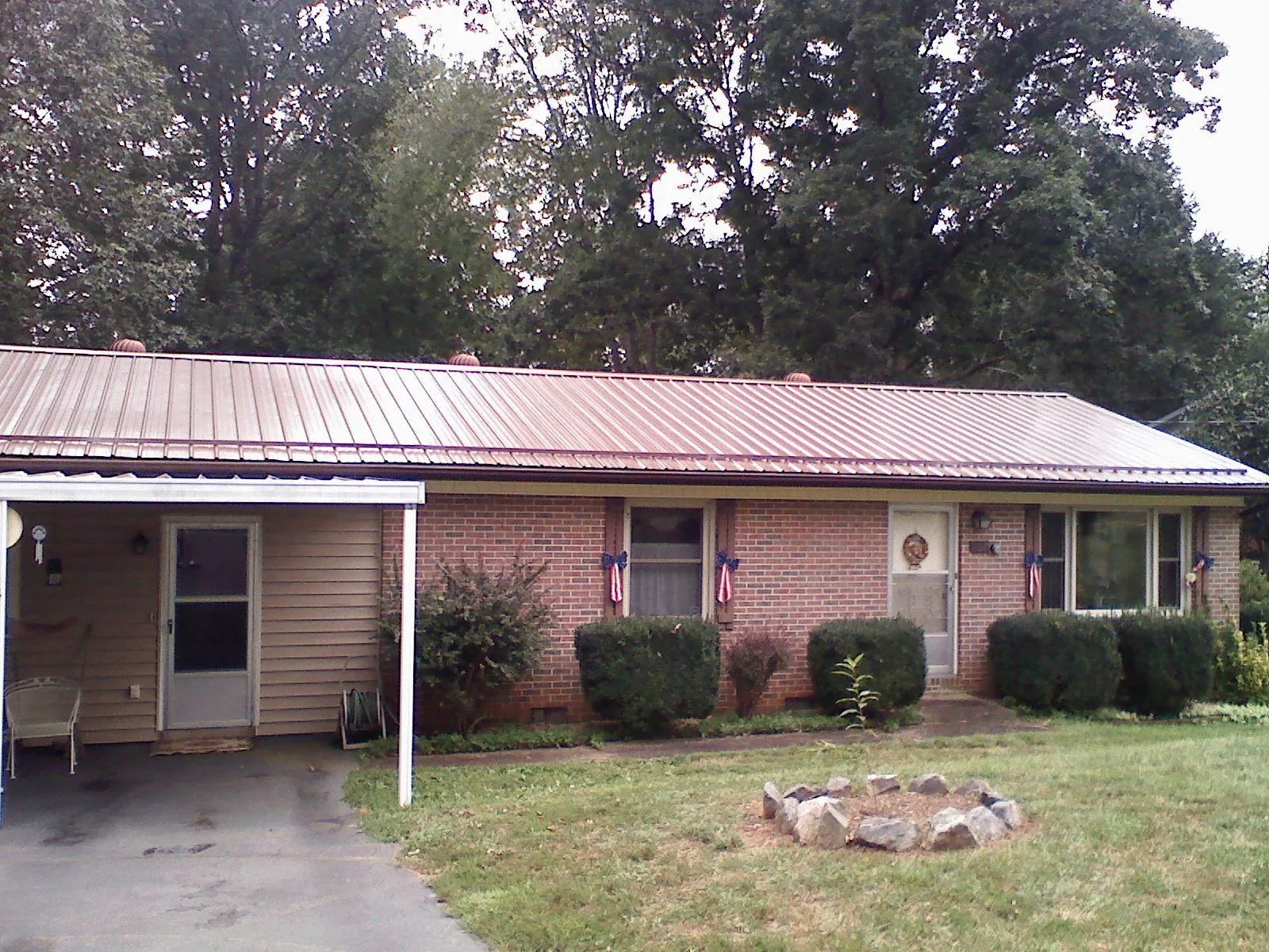 Bronze metal roof and carport on a brick ranch home — Roof Repair work by our crew in Pandora